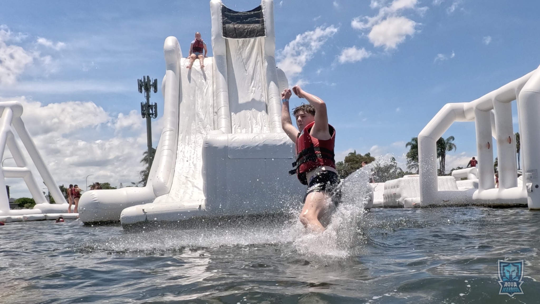 Aqua Warrior guest landing in the water after a slide